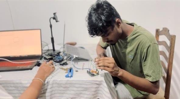 Project team member working on the mechanism during bench testing